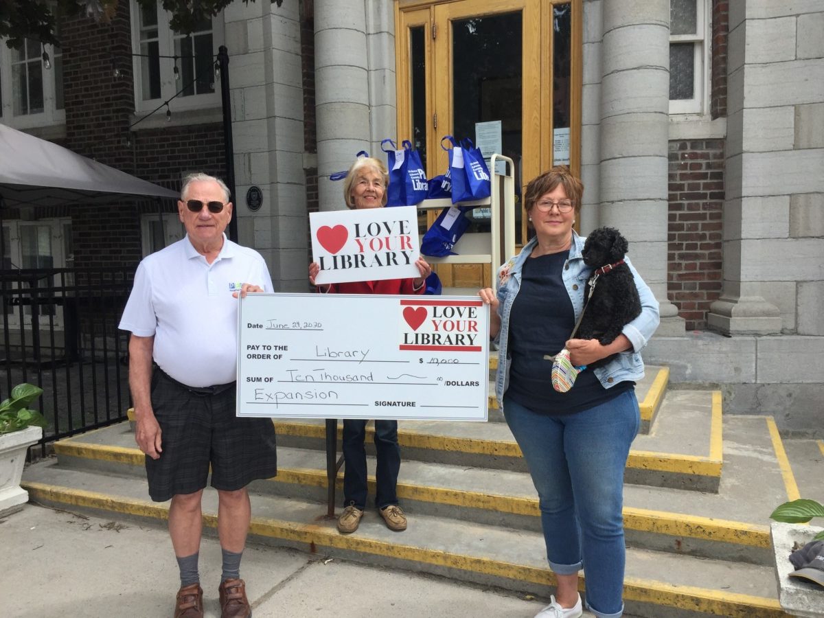 Pictured on the steps of the Picton Branch Library are: Don Wakefield, Chair of the Library Board Devon Jones, and Alexandra Bake, fundraising chair with fundraising mascot Chico.